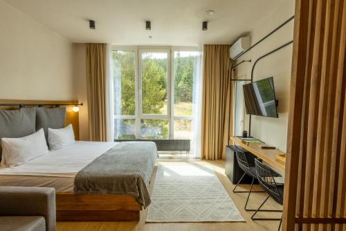 una camera d'albergo con un letto e una televisione di Bukville Hotel & SPA a Bukovel