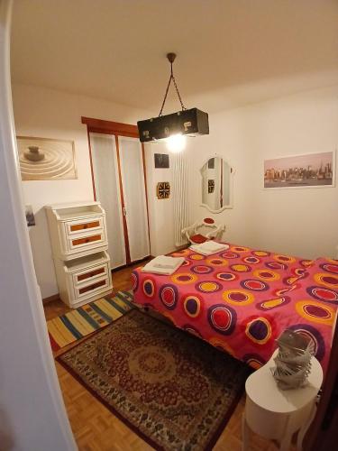 a bedroom with a bed with a red comforter at Attico 26 in Salcedo