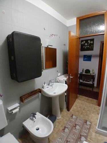 a bathroom with a sink and a tv on the wall at Attico 26 in Salcedo
