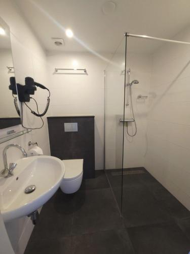 a bathroom with a shower and a sink and a toilet at De Blenck 69 in Callantsoog