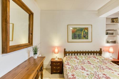 a bedroom with a bed and a dresser and a mirror at Art- Apartamentos Revilla Tacke E in Empuriabrava