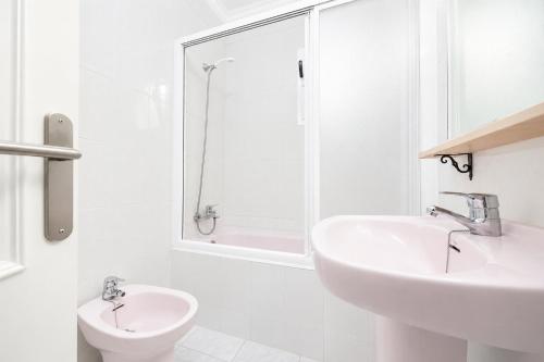 a white bathroom with a sink and a shower at Villa Emilio in Cala en Porter