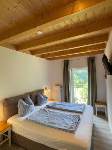 a bedroom with a large bed with blue pillows at Am Hof Jungholz in Jungholz