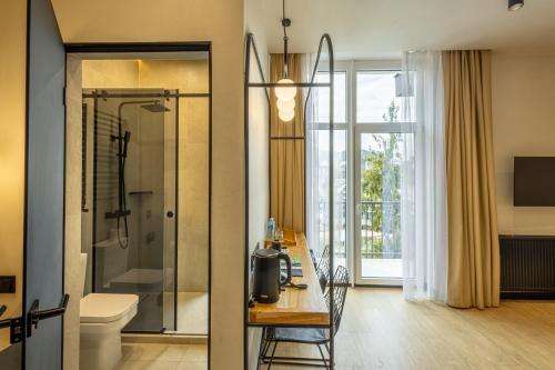 un bagno con doccia, WC e tavolo di Bukville Hotel & SPA a Bukovel