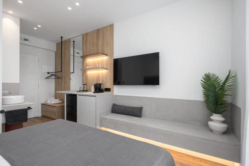 ein Schlafzimmer mit einer Couch und einem Fernseher an der Wand in der Unterkunft The Ark in Stavros