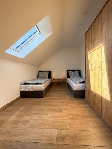 two beds in a room with a skylight at Kraatzer Ferienwohnungen in Gransee