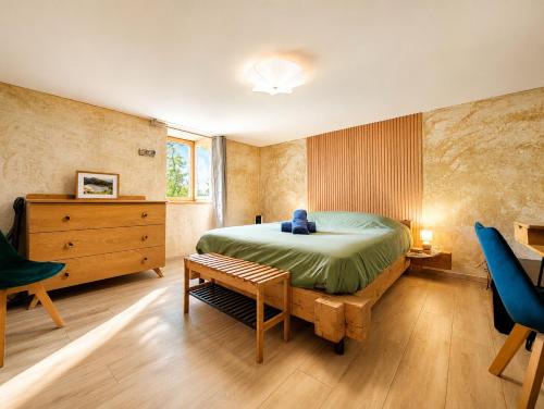 a bedroom with a bed and a dresser and a chair at Voyage éco-responsable Immersion nature Wifi in Belleydoux