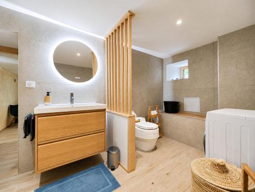 a bathroom with a sink and a toilet and a mirror at Voyage éco-responsable Immersion nature Wifi in Belleydoux