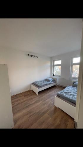 two beds in a room with wooden floors at Arnold Apartments 2 in Glauchau