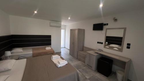 a small bedroom with two beds and a mirror at THALASSA BOUTIQUE HOTEL in Sarti