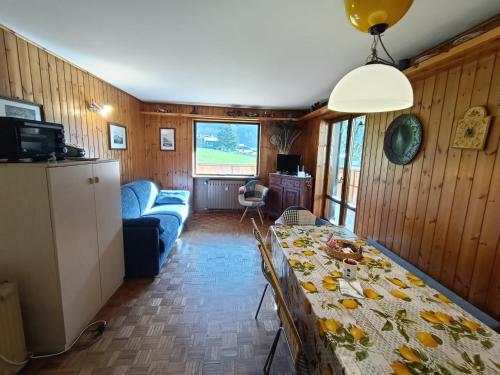 a dining room with a table and a couch at Le Rondinelle in Champoluc