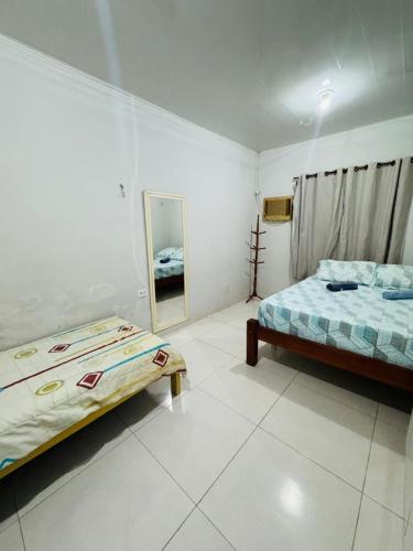 a bedroom with two beds and a mirror in it at Meu aconchego in Castanhal