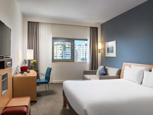 a hotel room with a bed and a living room at Novotel Kayseri in Kayseri