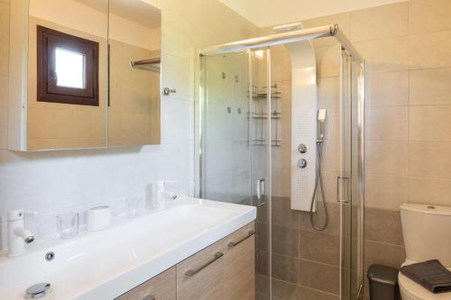 a bathroom with a shower and a sink and a toilet at Bella Garden House in Ierissos