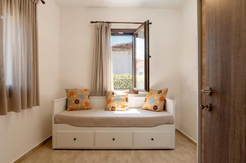 a small bedroom with a bed with a window at Bella Garden House in Ierissos