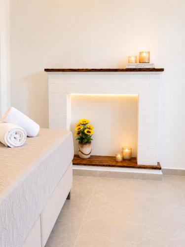 a room with a fireplace with a plant and candles at Maxa Residences - Free Airport Shuttle in Artemida