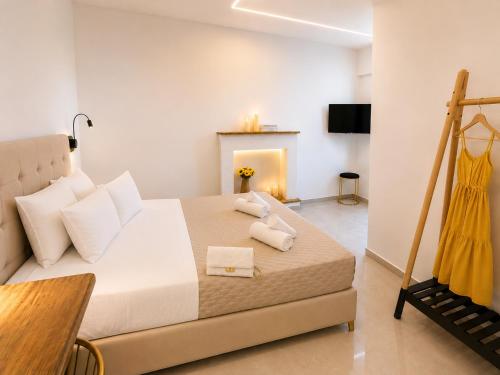 a bedroom with a bed with two towels on it at Maxa Residences - Free Airport Shuttle in Artemida