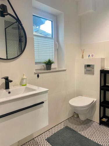 a white bathroom with a sink and a toilet at Domek Adam in Macharce