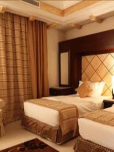 a hotel room with two beds and a mirror at اجنحة الخزامى المخدومة in Yanbu