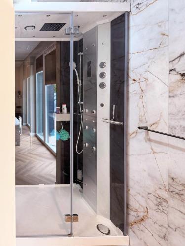 a shower with a glass door in a bathroom at Villa Aurelia Spa, Zeewolde 52 in Zeewolde