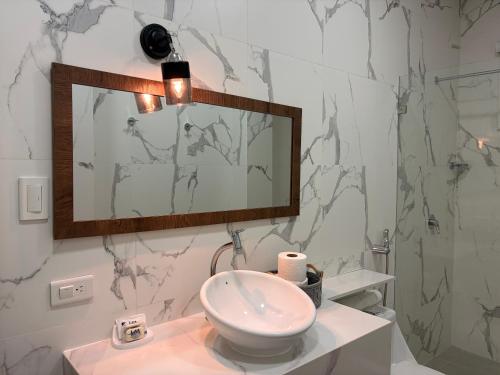 a bathroom with a sink and a mirror at Hotel La Mar Playas in Playas