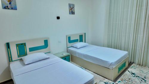 two beds in a small room with blue walls at Grand Stylish Two bedrooms Apartment in El Alamein