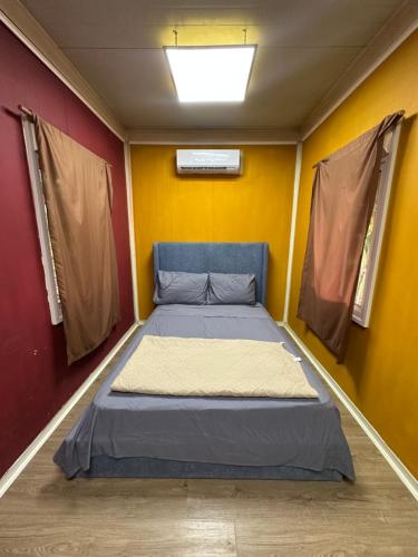a bed in a room with a yellow wall at La macana Ecotour in Cacique