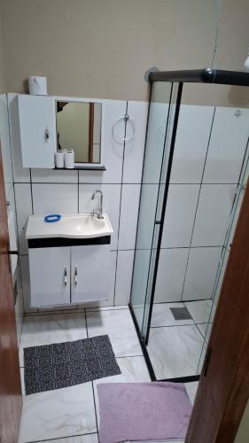 a bathroom with a sink and a mirror at Suites no centro, Salto-SP in Salto