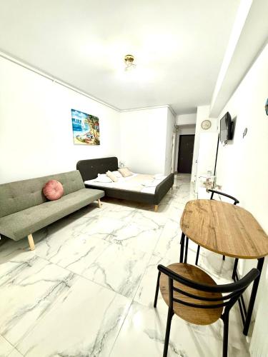 a living room with a couch and a table at Serene Studios in Eforie Nord