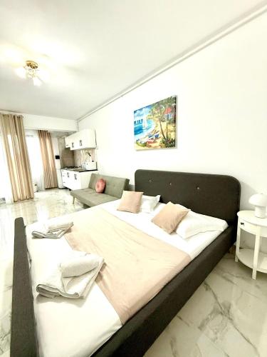 a large bed in a white room with at Serene Studios in Eforie Nord
