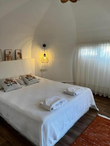 a bedroom with a white bed with two pillows on it at Vita Nova Hotel in Olympos