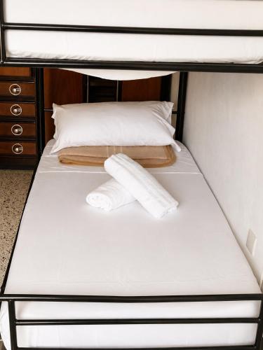 two rolls of paper towels sitting on top of a bunk bed at Ostello moderno centro- cucina Wi-Fi in Livorno