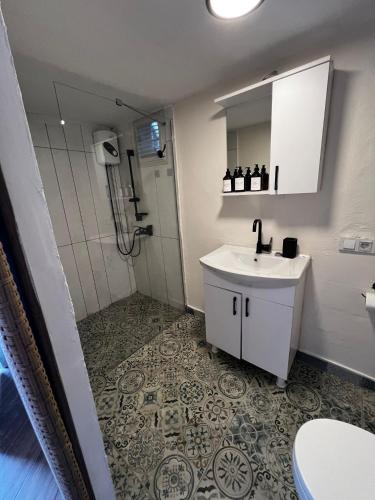 a white bathroom with a sink and a shower at Vita Nova Hotel in Olympos