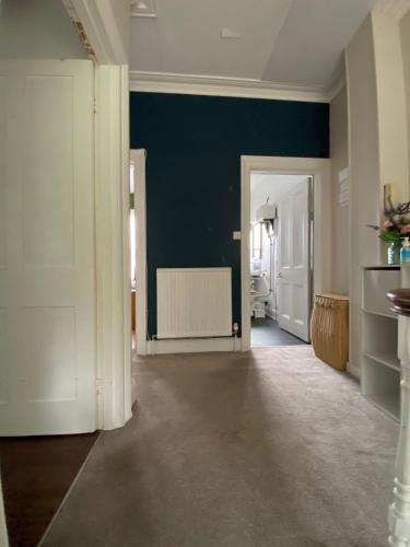 a hallway with a blue wall and a room with a radiator at City Centre Double Room in Truro
