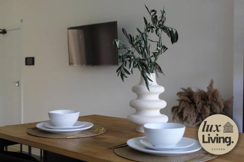 a wooden table with two cups and a vase on it at Lux Living No 6 Luxury 1-Bed Free Parking Oxford in Oxford