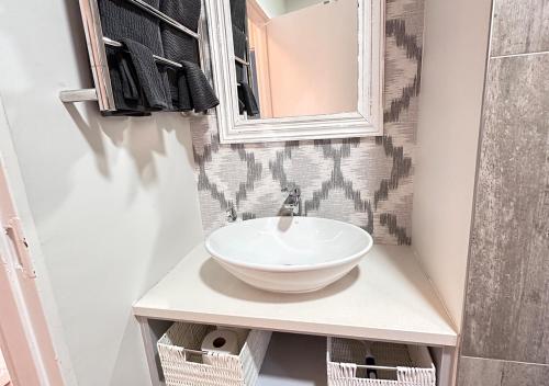 a bathroom with a sink and a mirror at The Fairway Apartment in Plettenberg Bay