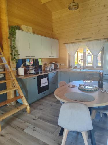 a kitchen with a table and a kitchen with white cabinets at domek przy Jodłowej in Niesulice