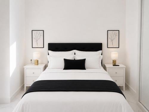 a white bedroom with a large white bed with two night stands at Holibai Antia Mare Centro de Baiona y mar in Baiona