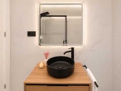 a bathroom with a black sink and a mirror at Holibai Antia Mare Centro de Baiona y mar in Baiona