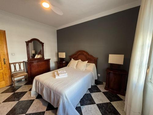 a bedroom with a bed and a mirror at La Casuca del Chiguito in Chipiona