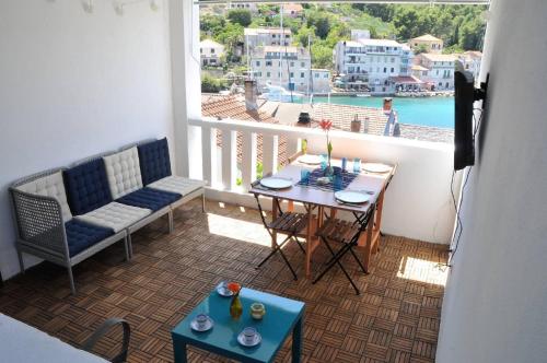 einen Balkon mit einem Tisch und Stühlen sowie Blick auf das Wasser in der Unterkunft Apartment Stomorska in Stomorska