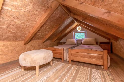 a attic bedroom with two beds and a stool at House Romance for two in Zagvozd