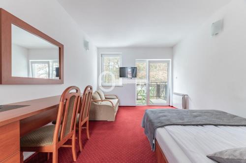 a bedroom with a bed and a desk with a mirror at Letnia Przystań Rowy in Rowy