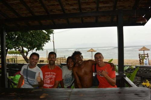 a group of men posing for a picture at the beach at Rock Pool Homestay in Huu