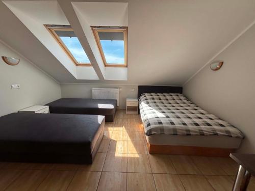 a attic bedroom with two beds and a couch at Pokoje Gościnne R10 in Rewa
