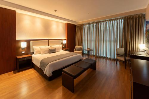 a hotel room with a bed and a large window at Hotel Ciudad de David in David
