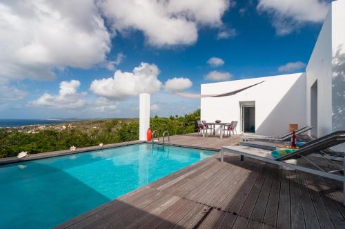 a villa with a swimming pool and a wooden deck at Bonaire Bay View Villa in Kralendijk