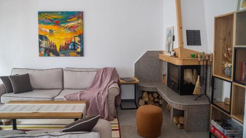 a living room with a couch and a painting on the wall at Kaba Home - Mountain Villa with Sauna in Stoykite