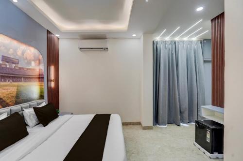 a bedroom with a bed and a painting on the wall at Hotel O Maruti Hotel in Indirapuram