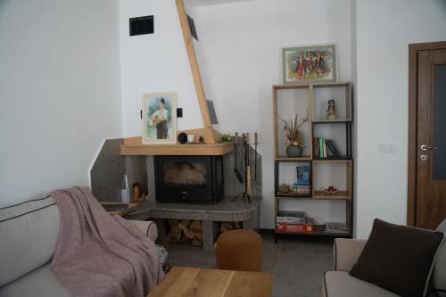 a living room with a couch and a fireplace at Kaba Home - Mountain Villa with Sauna in Stoykite